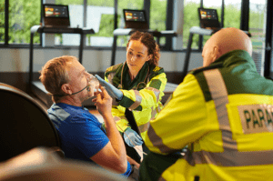 Two paramedics supporting a patient on oxygen  