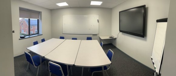 white tables, blue chairs, flipchart, projector